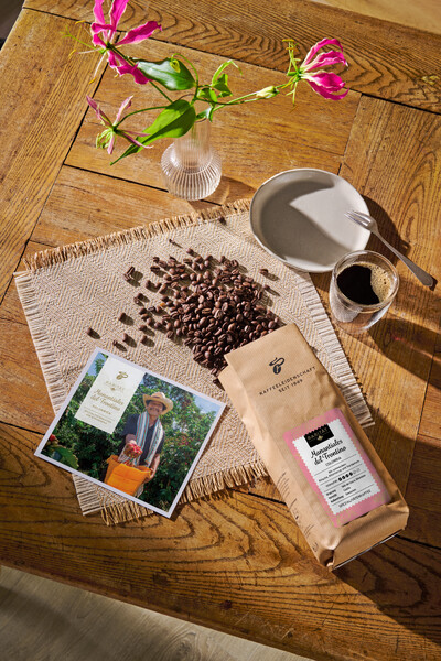 Kaffeebohnen, Tasse, Fotokarte und Vase auf Holztisch