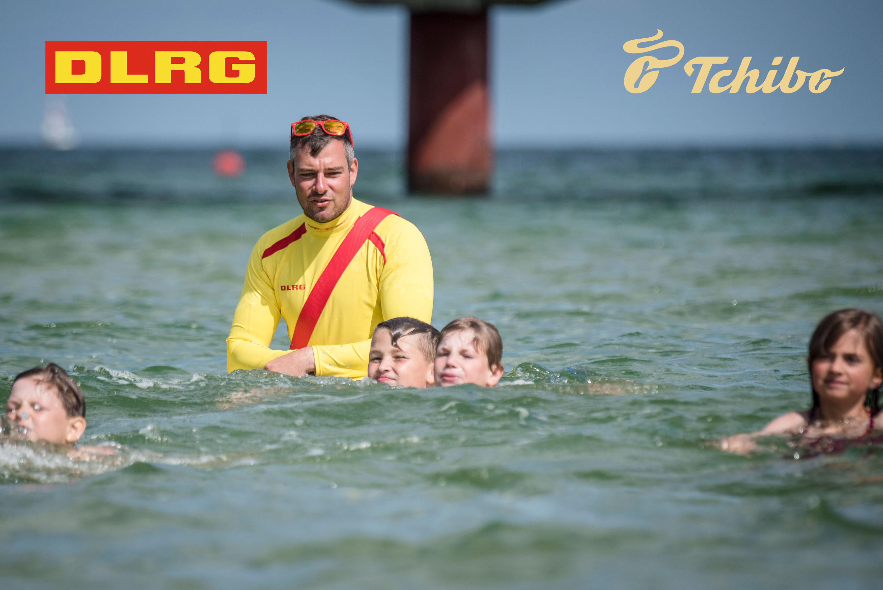 DLRG-Rettungsschwimmer betreut Kinder im Meer