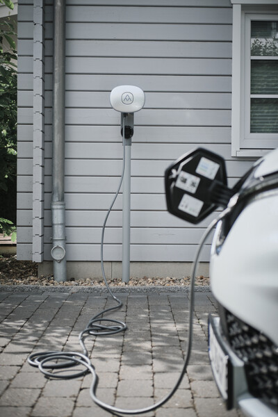Ladestation lädt Elektroauto vor Hauswand