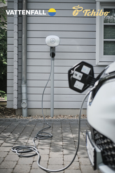 E-Auto lädt an Wallbox vor Hausfassade