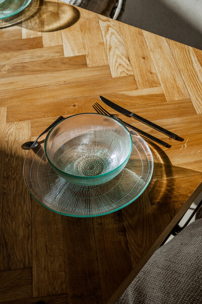 Glasbesteck mit Teller und Schüssel auf Holztisch