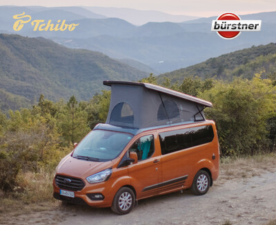 Orange Campingbus mit Aufstelldach in Berglandschaft