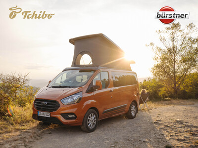 Orangefarbener Campervan im Sonnenuntergang