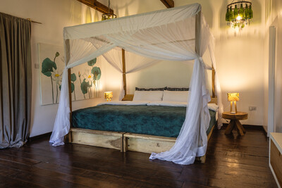 Helles Schlafzimmer mit Himmelbett und Blumenbild