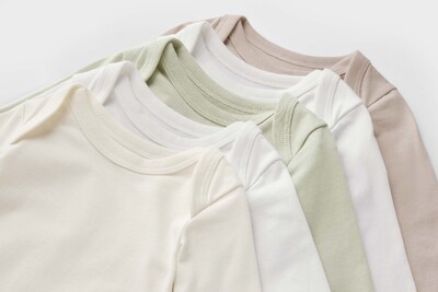 Fünf Babybodys in neutralen Pastellfarben
