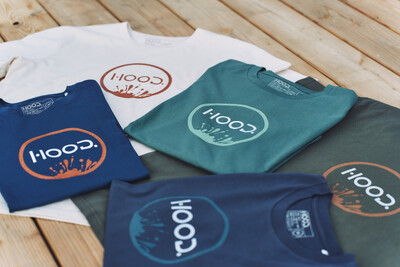 Mehrere bunte T-Shirts mit HOOD-Logo auf Holz