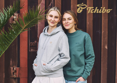Zwei Personen in Hoodies vor Container mit Tchibo-Logo
