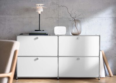 Weißes Sideboard mit Lampe, Router und Vase