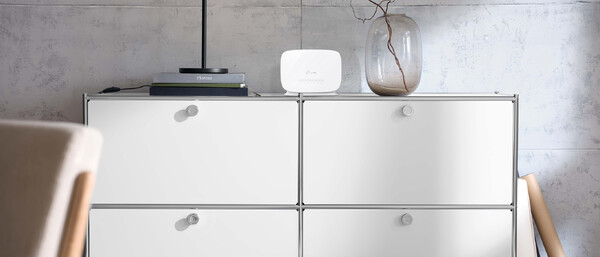 Weißes Sideboard mit Lampe, Router und Vase