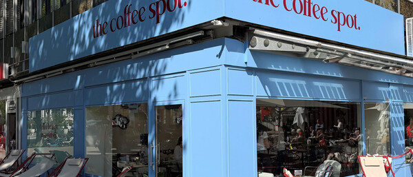 Blaues Straßencafé mit Liegestühlen vor den Fenstern