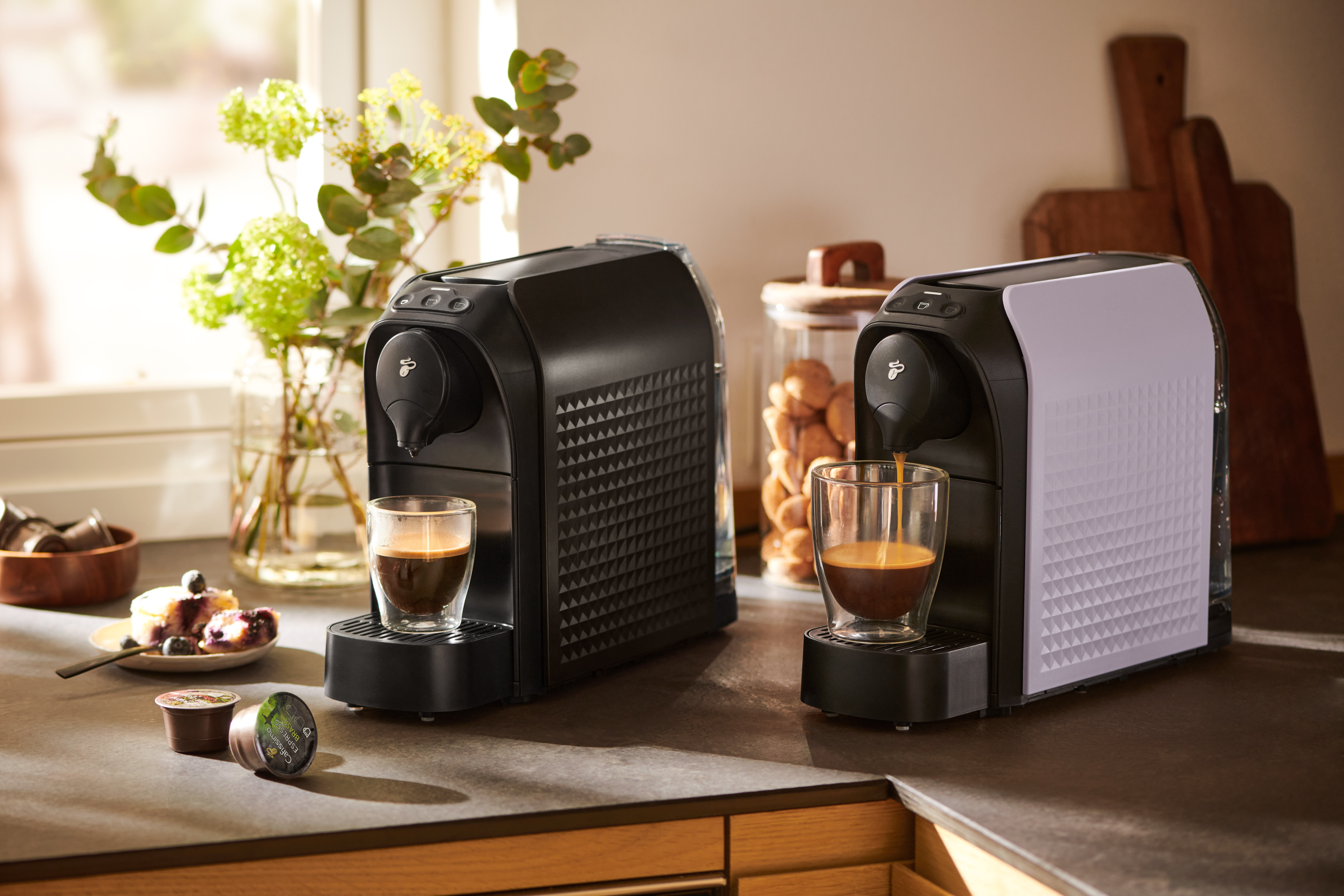Zwei Kapselmaschinen mit Espresso in heller Küche