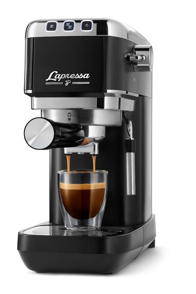 Schwarze Espressomaschine brüht Kaffee in Glas