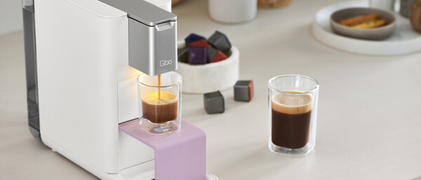 Kapsel-Kaffeemaschine brüht Espresso in Glas