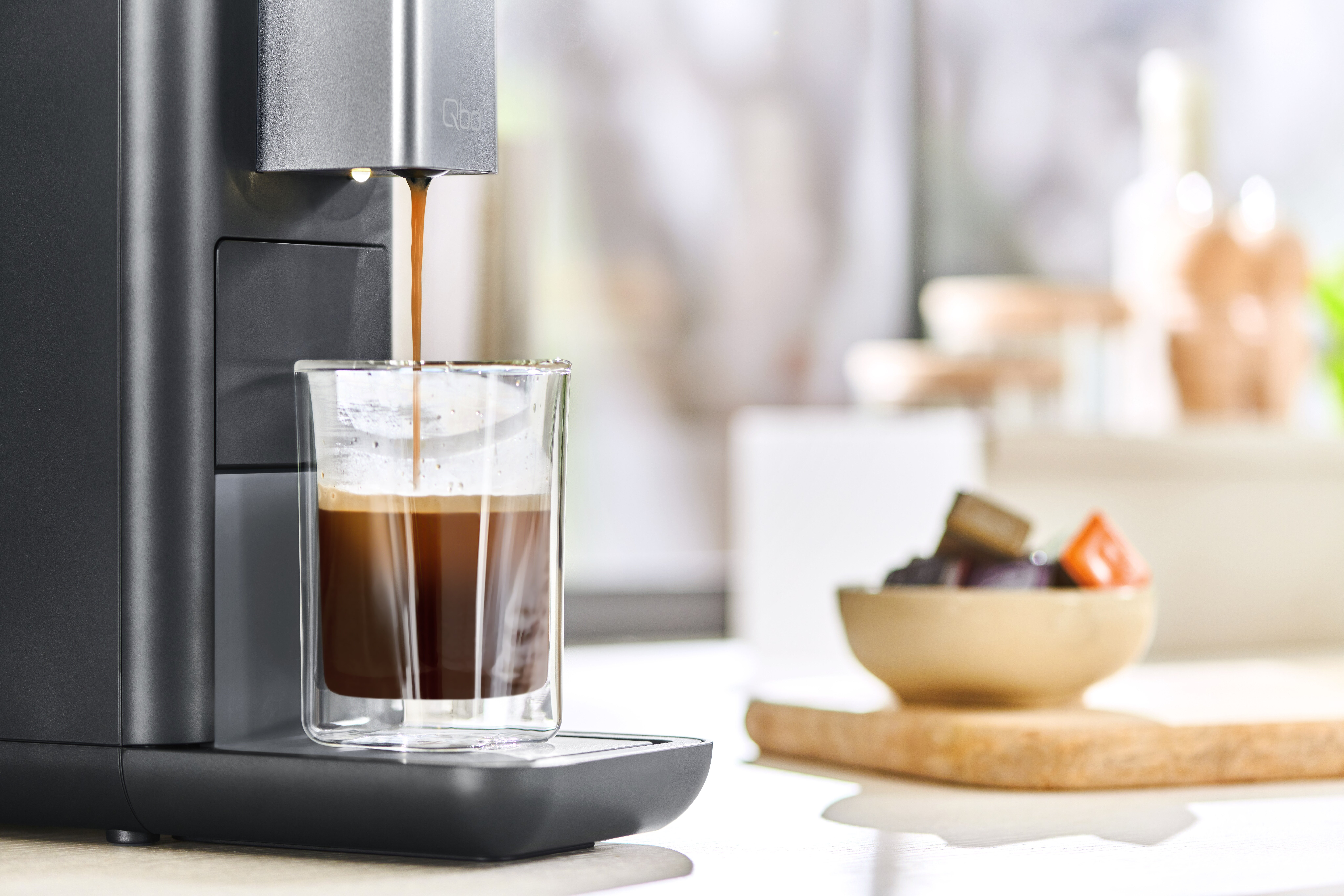 Kaffeemaschine brüht Espresso in Glasbecher