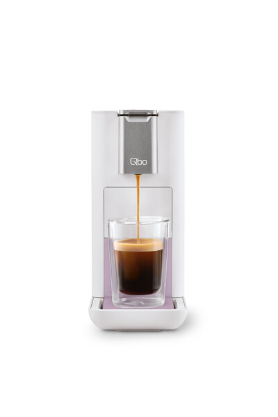 Weiße Kapselmaschine brüht Espresso in Glas