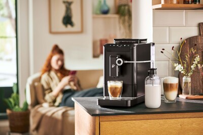 Kaffeevollautomat mit Milchflasche in gemütlicher Küche