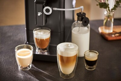 Kaffeemaschine mit vier Latte-Gläsern und Milchkaraffe