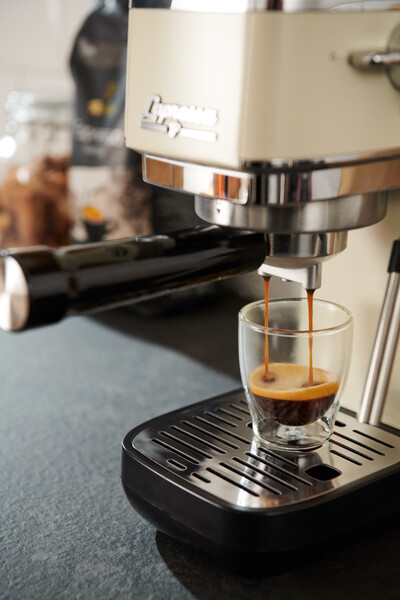 Espressomaschine füllt Glas mit frischem Espresso
