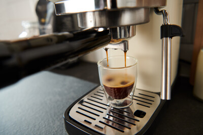 Espressomaschine füllt Glas mit frischem Espresso