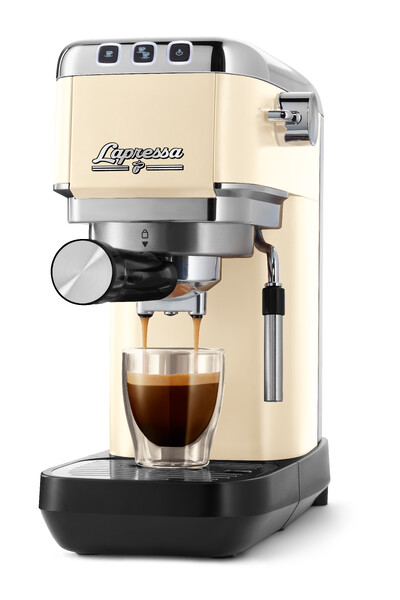 Cremefarbene Espressomaschine mit vollem Glas