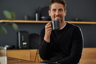 Person trinkt Kaffee aus schwarzer Tasse