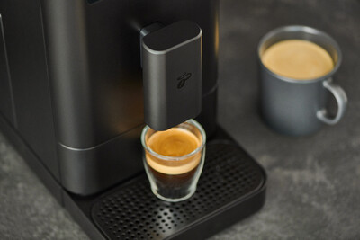 Espressomaschine mit Glas und grauer Tasse