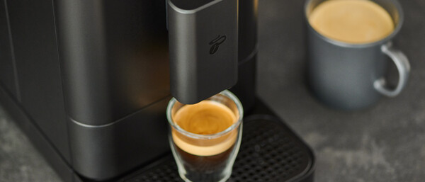 Espressomaschine mit Glas und grauer Tasse