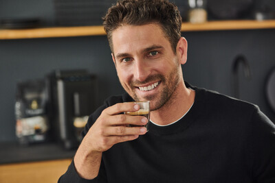 Mann trinkt Espresso in moderner Küche