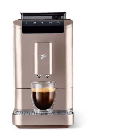 Goldene Kaffeemaschine mit Glas Espresso