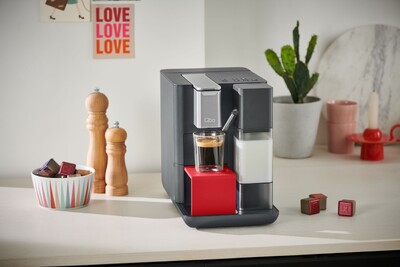 Moderne Kaffeemaschine mit Glas Espresso auf Küchenarbeitsplatte