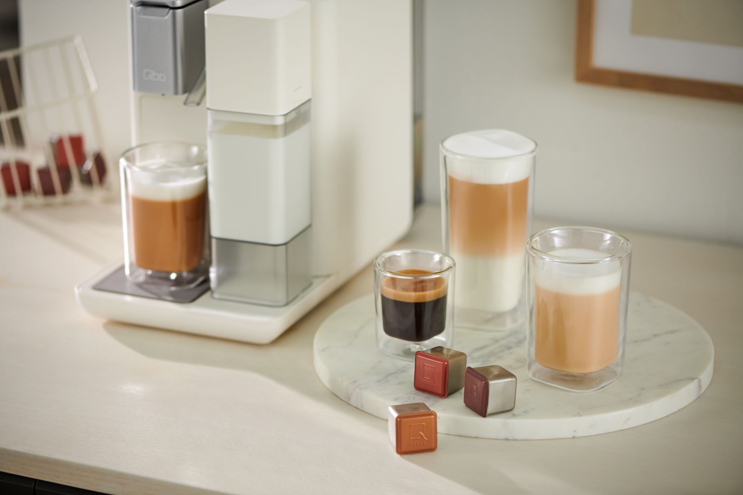 Kaffeemaschine mit Milchbehälter und vier Getränken