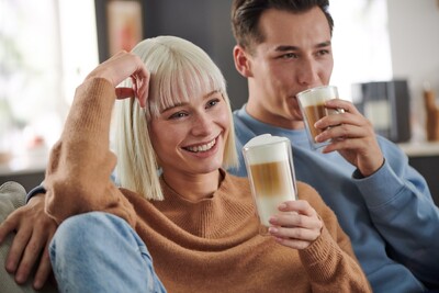 Zwei Personen entspannen auf Sofa mit Latte Macchiato