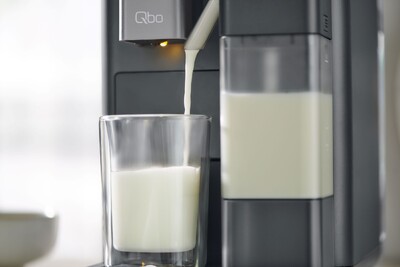 Milch fließt aus Maschine in ein Glas