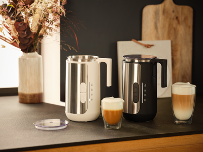 Zwei Milchaufschäumer und Gläser mit Latte Macchiato