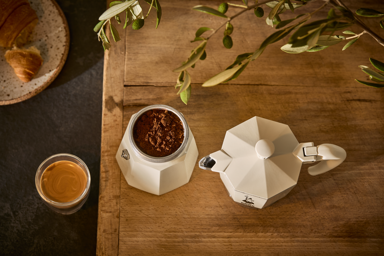 Espressokanne, Kaffeepulver, Glas Kaffee, Croissant