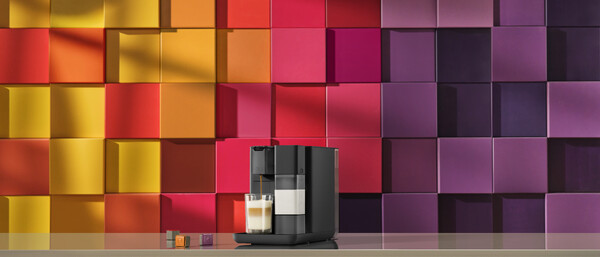 Kaffeemaschine vor bunter Würfelwand