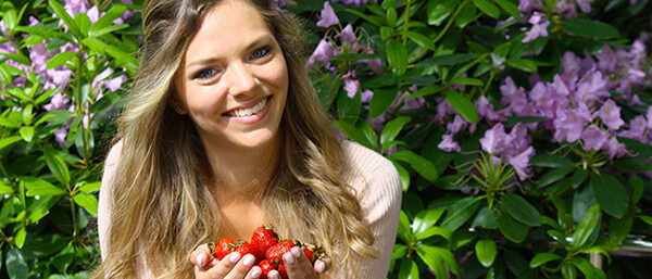 Praktikantin Jenny freut sich über den Start der deutschen Erdbeersaison