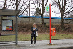 Marie wartet auf bis der Bus kommt