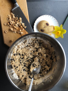 Teigschüssel mit Löffel, Nüsse und Ostergebäck