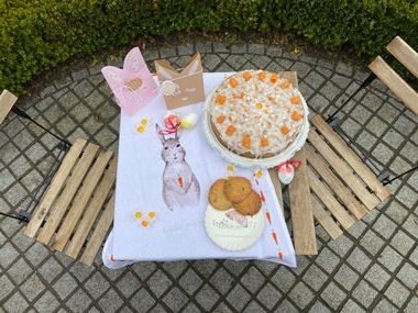 Osterkuchen, Kekse und Karten auf Gartentisch