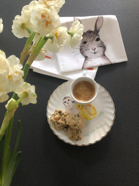 Espresso mit Keksen, Blumen und Serviette mit Hase