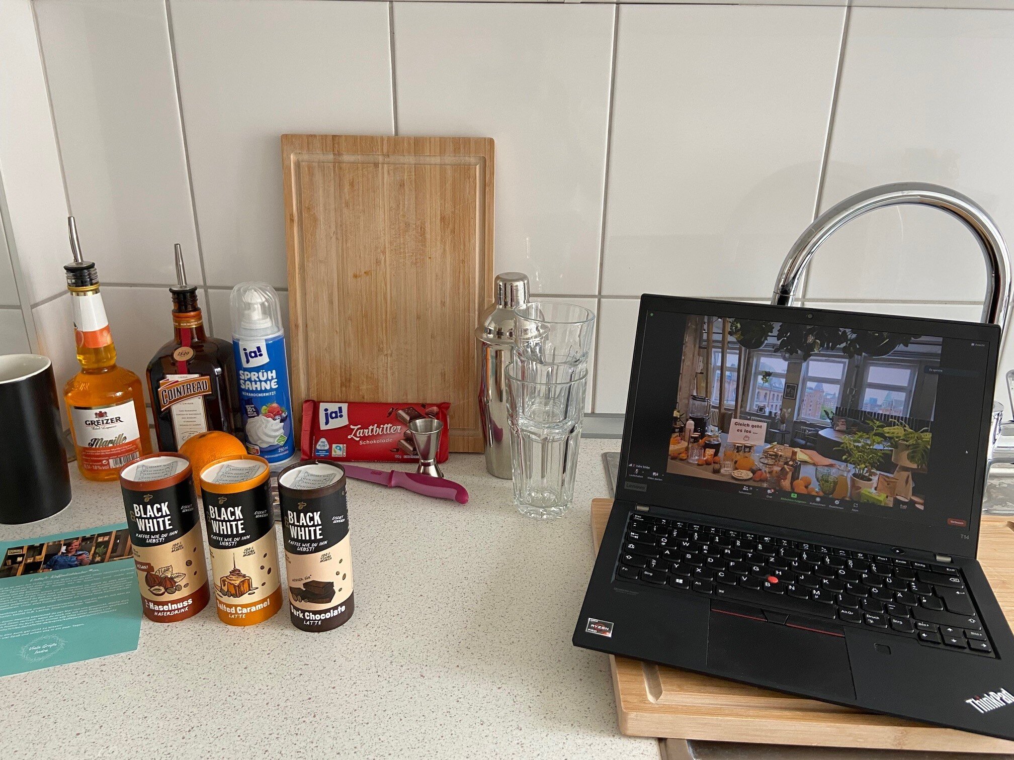 Küchenarbeitsfläche mit Laptop und Cocktailzutaten