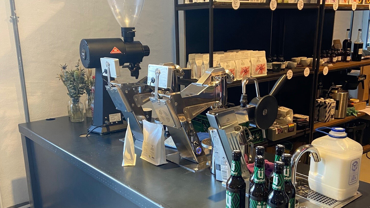 Moderne Kaffeebar mit Mühle, Brühstation und Regalen