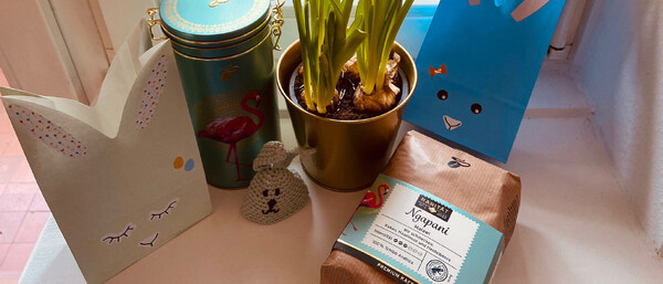 Osterdeko mit Narzissen, Geschenktüten und Kaffee