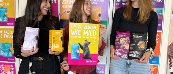 Drei Personen halten Eduscho-Kaffeepackungen