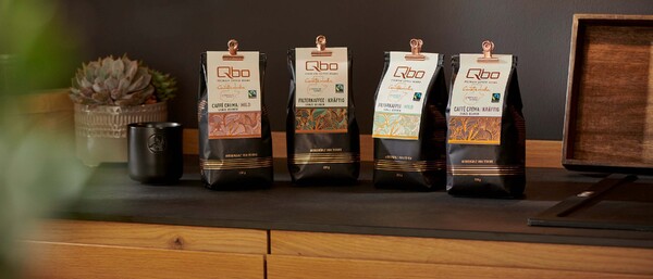 Vier Qbo-Kaffeepackungen auf Holztheke