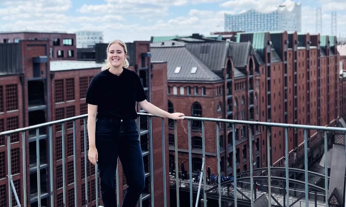 Person auf Dachterrasse vor Backstein-Speicherstadt