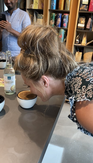 Link: Großansicht des Bildes - Bildinhalt: Frau riecht an einer Kaffeetasse in Café-Bar
