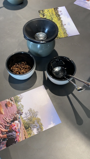 Link: Großansicht des Bildes - Bildinhalt: Kaffeetassen mit Bohnen und Löffeln neben Fotos