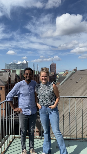 Link: Großansicht des Bildes - Bildinhalt: Zwei Personen auf Dachterrasse mit Stadtpanorama